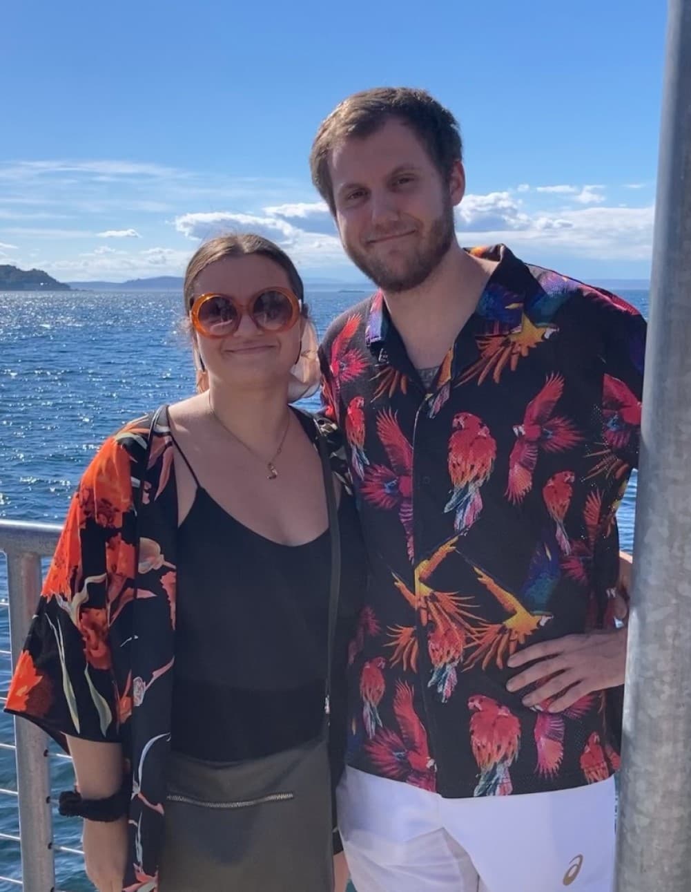 Alissa and Matt in tropical shirts arm in arm by the Puget